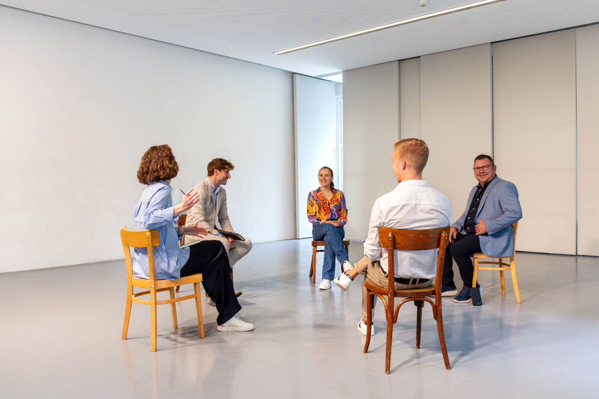 Mediationsgespräch — drei Personen an einem Tisch im Gespräch