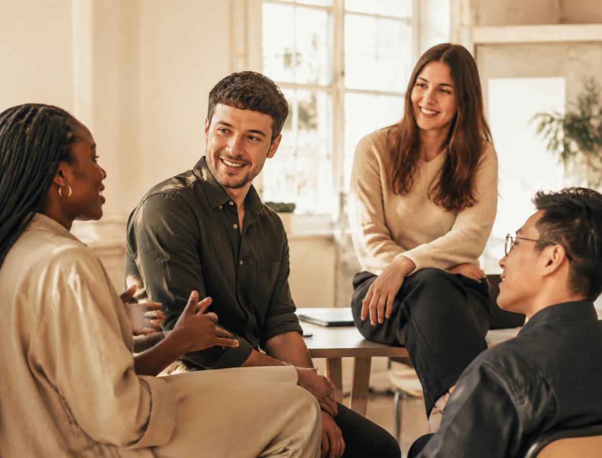 Team im lebendigen Austausch in einem hellen Arbeitsraum