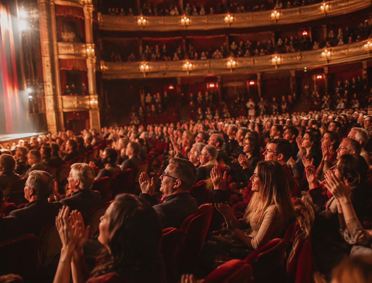 Applaudierendes Publikum in einem stimmungsvollen Theatersaal